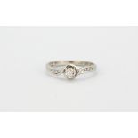 A 9ct white gold diamond set solitaire ring with diamond set shoulders, (M).