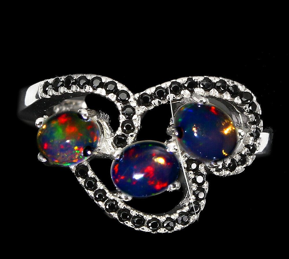 A matching 925 silver ring set with cabochon cut opals and black spinels, (L.5).