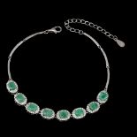 A 925 silver bracelet set with oval cut emeralds and white stones, L. 7cm.