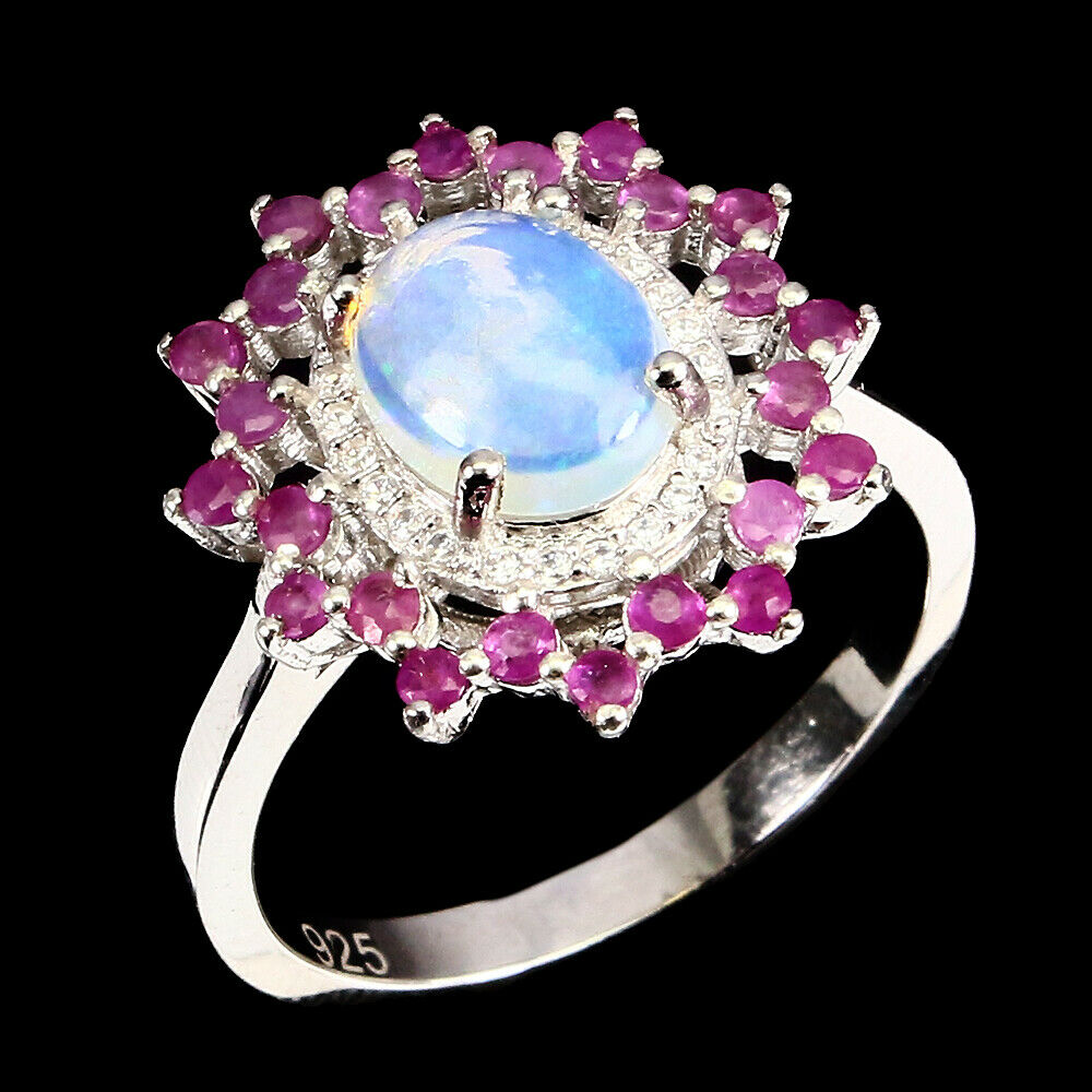 A 925 silver cluster ring set with a cabochon cut opal surrounded by rubies, (R.5). - Image 2 of 2