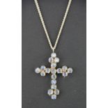 A silver and moon stone cross on a heavy silver chain.