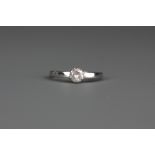 An 18ct white gold brilliant cut diamond set solitaire ring, (P).