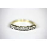 A 9ct yellow gold diamond set half eternity ring, (N.5).