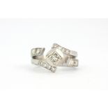 An 18ct white gold rings et with a princess cut diamond and brilliant cut diamond set shoulders, (