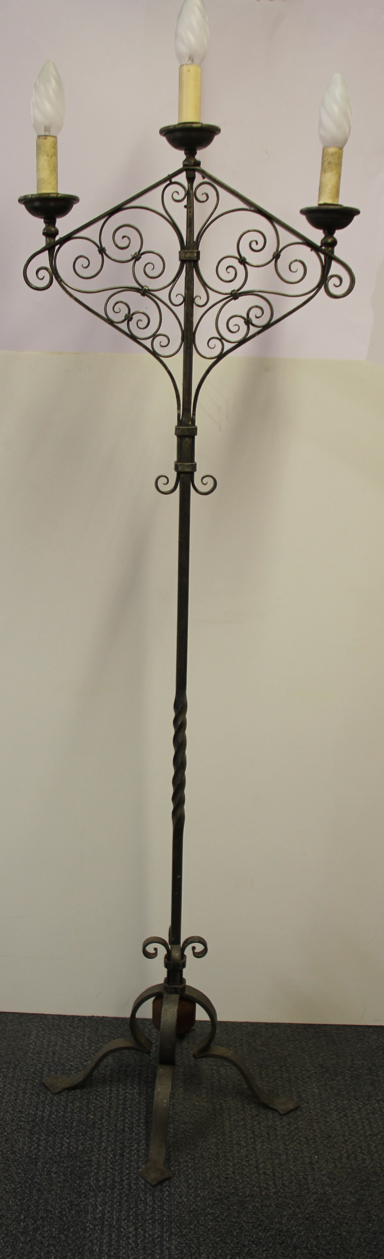 An early 20th Century ecclesiastical style iron candle holder converted for use with electricity, H.