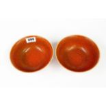 A pair of Chinese orange/red glazed porcelain bowls, Dia. 16cm.