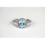 A 925 silver halo ring set with an oval cut blue topaz and white stones, (L).