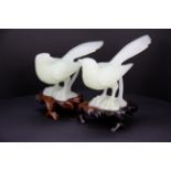 A pair of Chinese carved jade / hardstone figures of birds on carved wooden bases, L. 13cm. H.