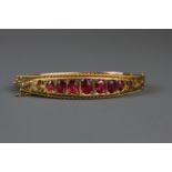 An early 20th Century 9ct yellow gold (stamped 375) stone set bangle, L. 6.5cm.
