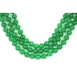 A lovely three row necklace of green jade beads, the bead size 8mm, the necklace L. 40cm, on a white