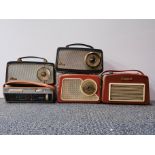 Five vintage portable radios.