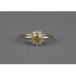 A white metal (tested 18ct gold) cluster ring set with a brilliant cut fancy yellow diamond