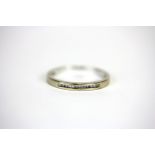 An 18ct white gold diamond set half eternity ring, (M.5).