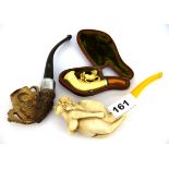 A cased meerschaum cheroot holder (A/F) together with a further meerschaum pipe with a bird claw