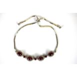 A 925 silver adjustable bracelet set with cabochon cut rubies.