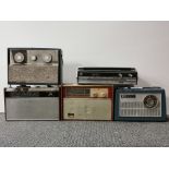 Five vintage portable radios.