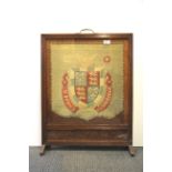 A 1920's oak fire screen in set with a tapestry panel for St. John's College in Cambridge, H. 77cm.