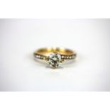 An 18ct rose gold solitaire ring set with a 1ct brilliant cut diamond and diamond set shoulders, (