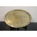An Eastern brass topped folding table, Dia. 61cm.