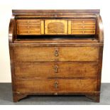 A Biedermeier mahogany veneered tambour front bureau with pull out writing table and maple and