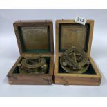 Two reproduction cased sun dial compasses.