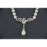 An unusual single row necklace of 7.5mm cultured pearls with a white metal and pearl centrepiece, L.