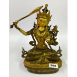 A Tibetan gilt bronze temple style figure of a seated Tara with hand painted facial features, H.