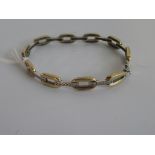 A 9ct gold and diamond bracelet, the bi-coloured oval links with seven stone diamond set bars,