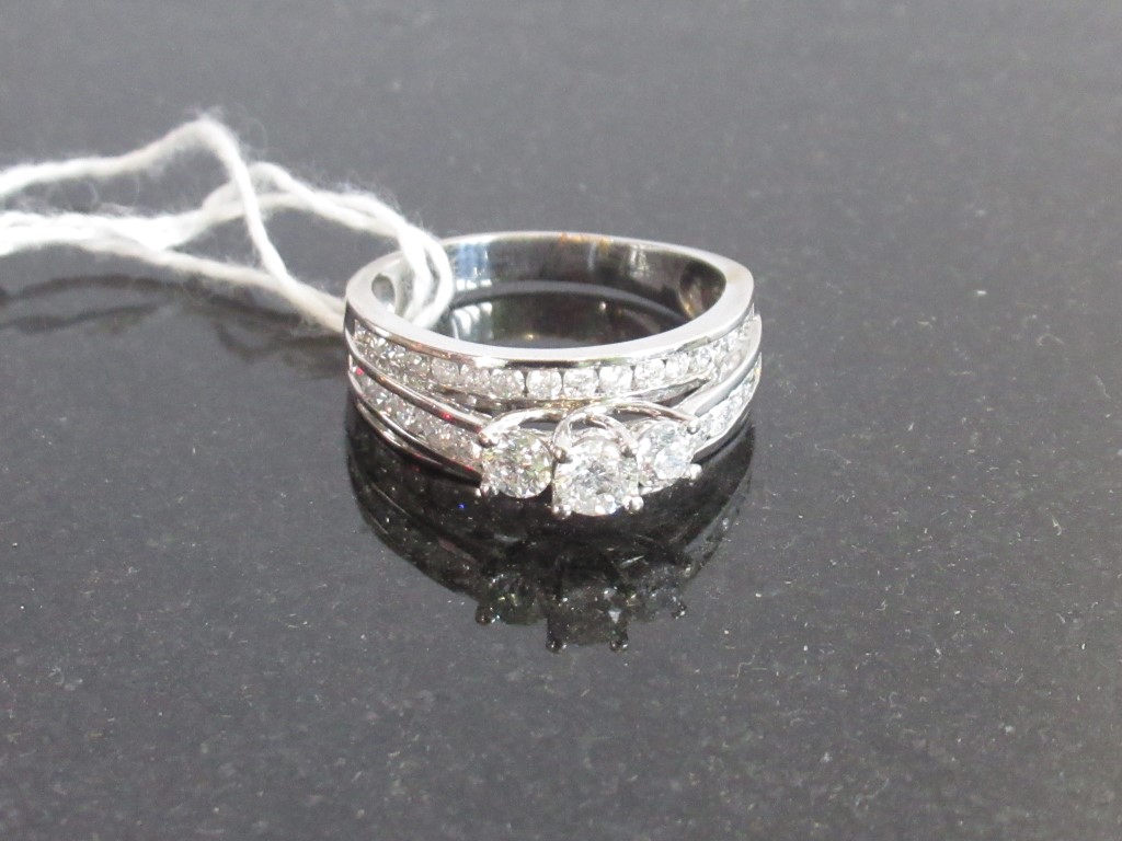 A three row diamond ring, the central row set with three brilliant cut diamonds in claw mounts,