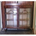 A mahogany display cabinet of bow front outline, raised on cabriole legs (122cm wide).