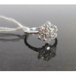 A diamond cluster ring, the seven brilliant cut diamonds in claw mounts to a plain 18ct gold shank,