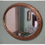 An early 20th century oval gilt framed wall mirror with ribbon decoration.