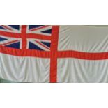 A large Royal Navy ensign flag with Union Jack to one corner.