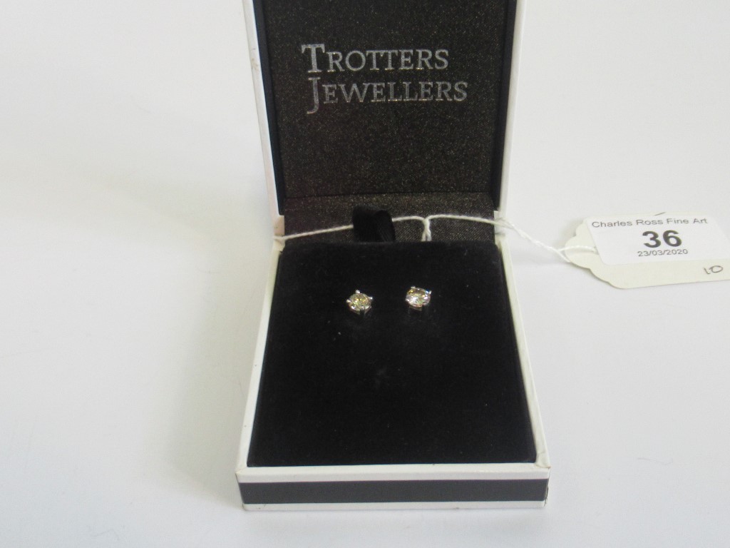 A pair or single stone diamond earrings,