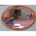 An oval decorative gilt framed wall mirror, with beaded surround.