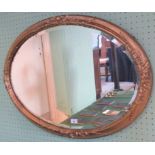 An early 20th century oval gilt framed wall mirror with ribbon decoration.