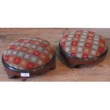 A pair of Victorian figured walnut and ebonised circular footstools, with needlework pattern tops.