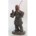 A 19th century Chinese carved root wood figure of a fisherman with inset glass eyes.