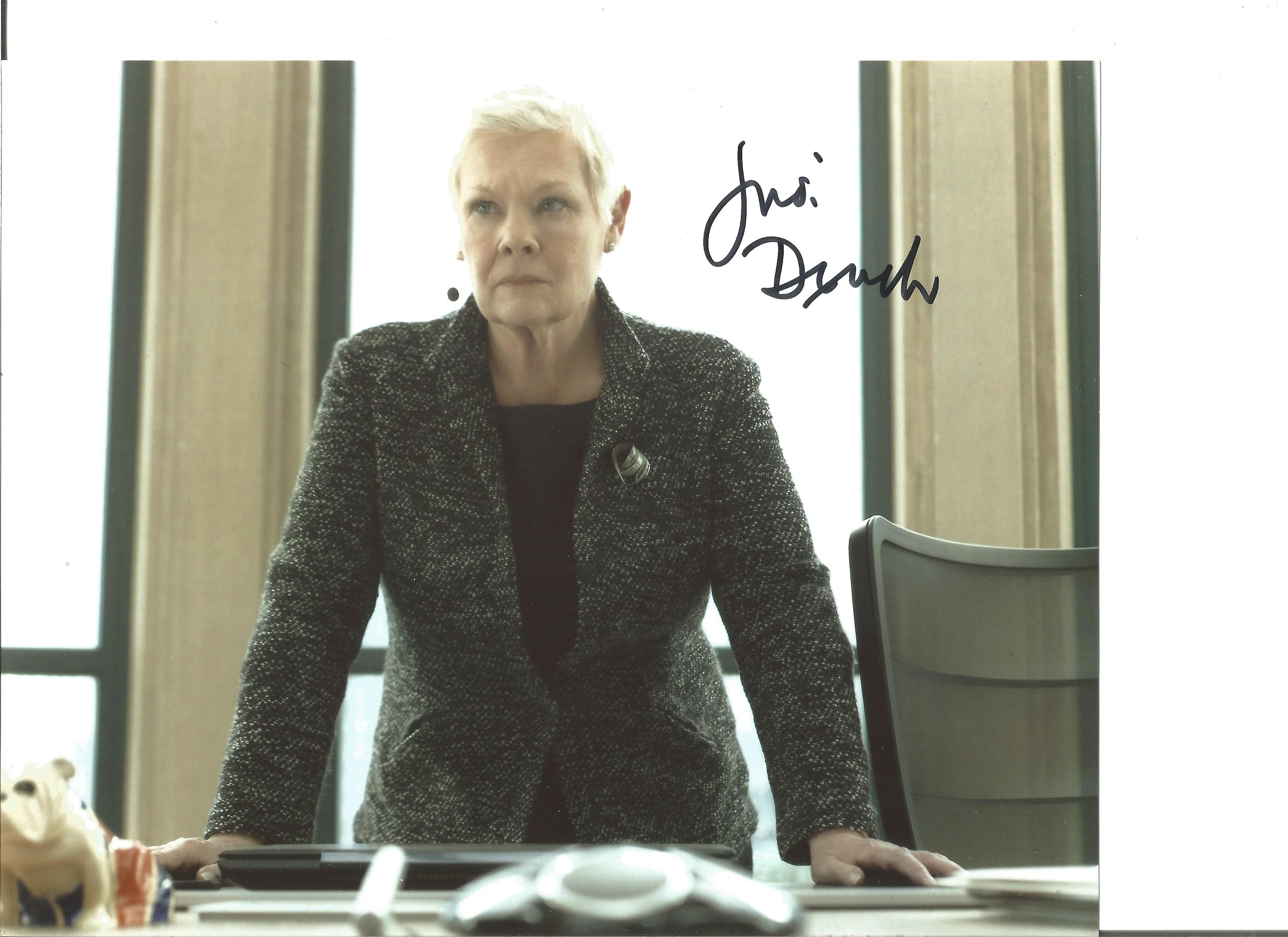 James Bond Judi Dench as M signed 10 x 8 inch colour photo standing behind her desk. Good Condition.