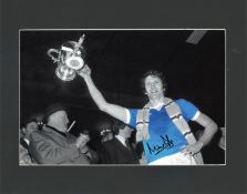 Mike Doyle signed 14x11 mounted colourised photo pictured during his playing days with Manchester