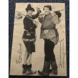 Laurel and Hardy signed 7 x 5 inch sepia photo dressed in tramp outfits waving.