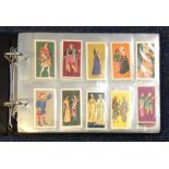 Cigarette card collection in half size album. Includes Brooke bond set British costumes 1967, Saga