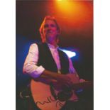 Mike Rutherford signed 12 x 8 inch colour photo playing guitar on stage, co-founded the rock band