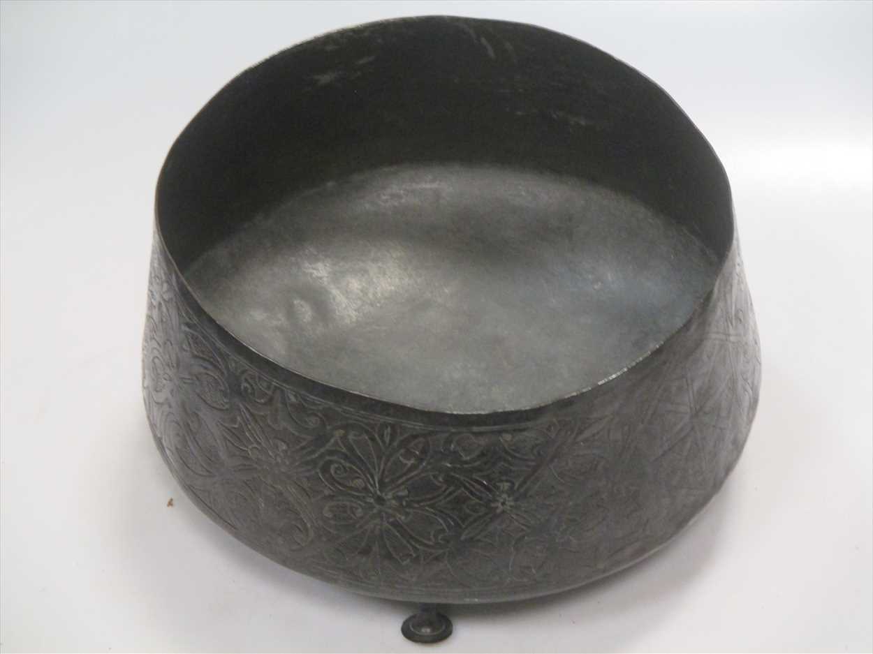 A Persian bronze bowl, raised on three feet, 27cm diameter