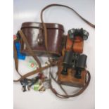 A collection of vintage leather cased binoculars, a Leica camera and other assorted leather cases