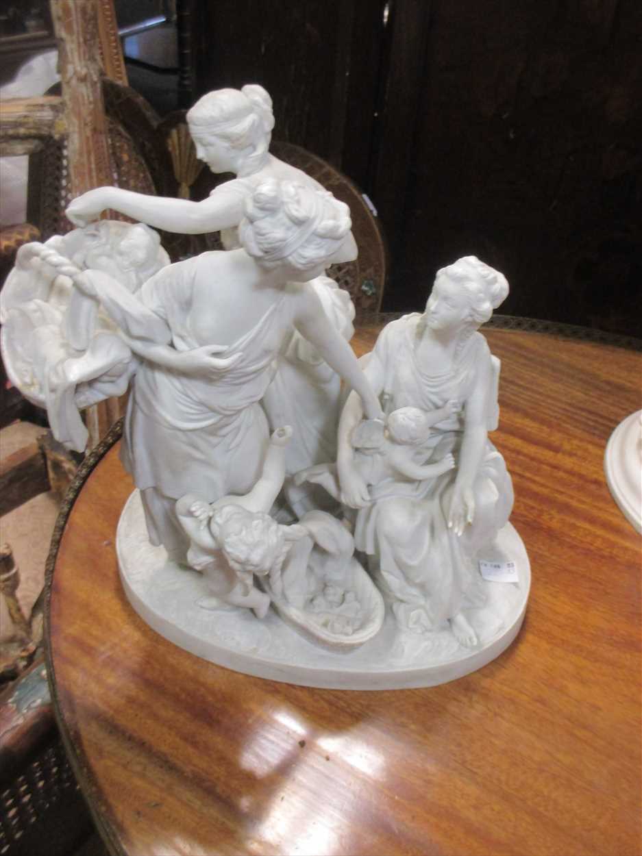 A 19th century bisque porcelain group of three classily dressed ladies, together with putti standing