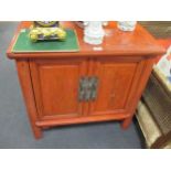 A pair of early 20th century Chinese red laquer side cabinets of slight uptapering form each with