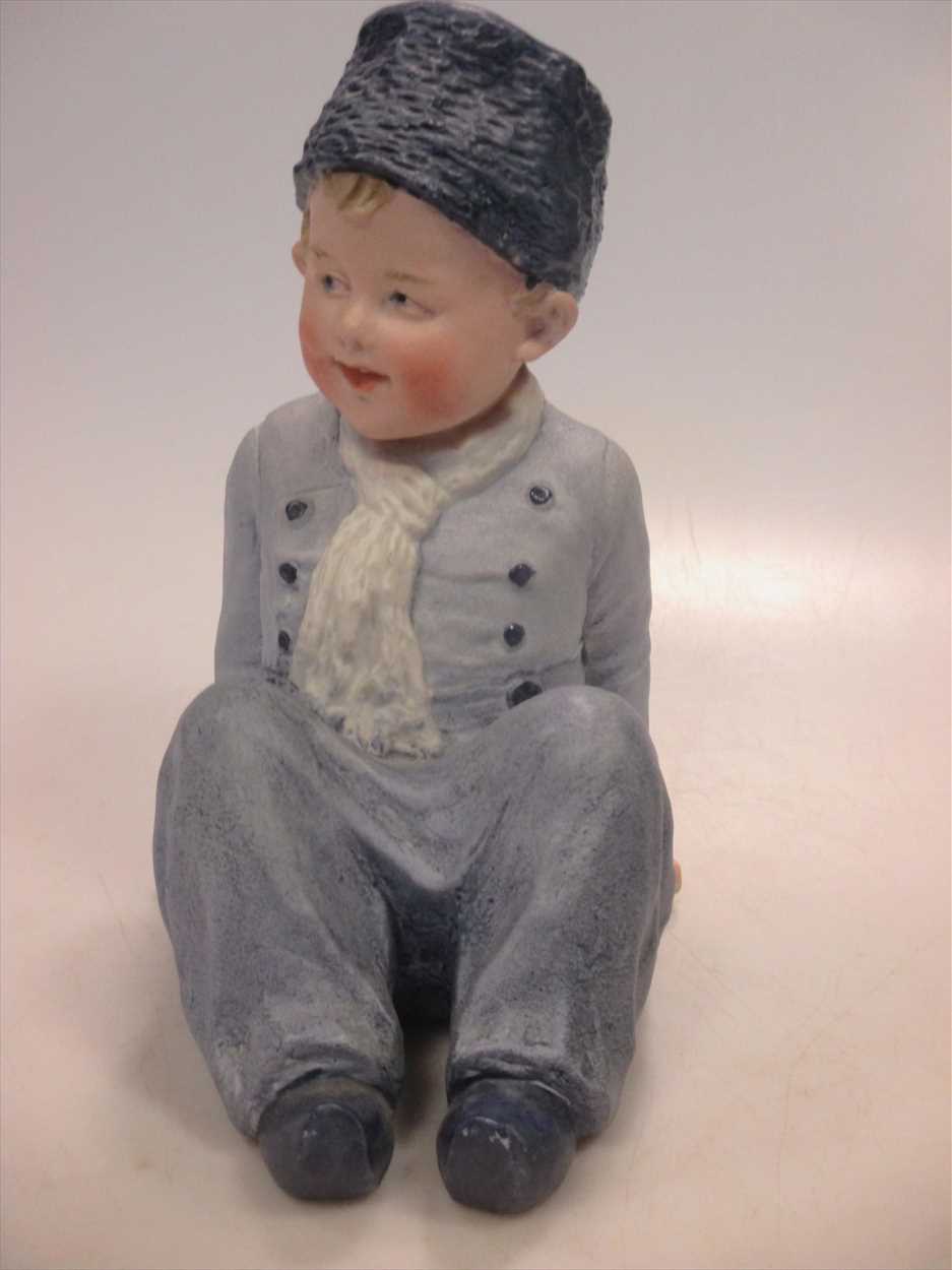 A Heubach piano doll of a young boy.