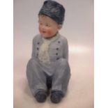 A Heubach piano doll of a young boy.