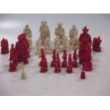 An early 19th century Cantonese carved ivory chess set to include fifteen red and fourteen white